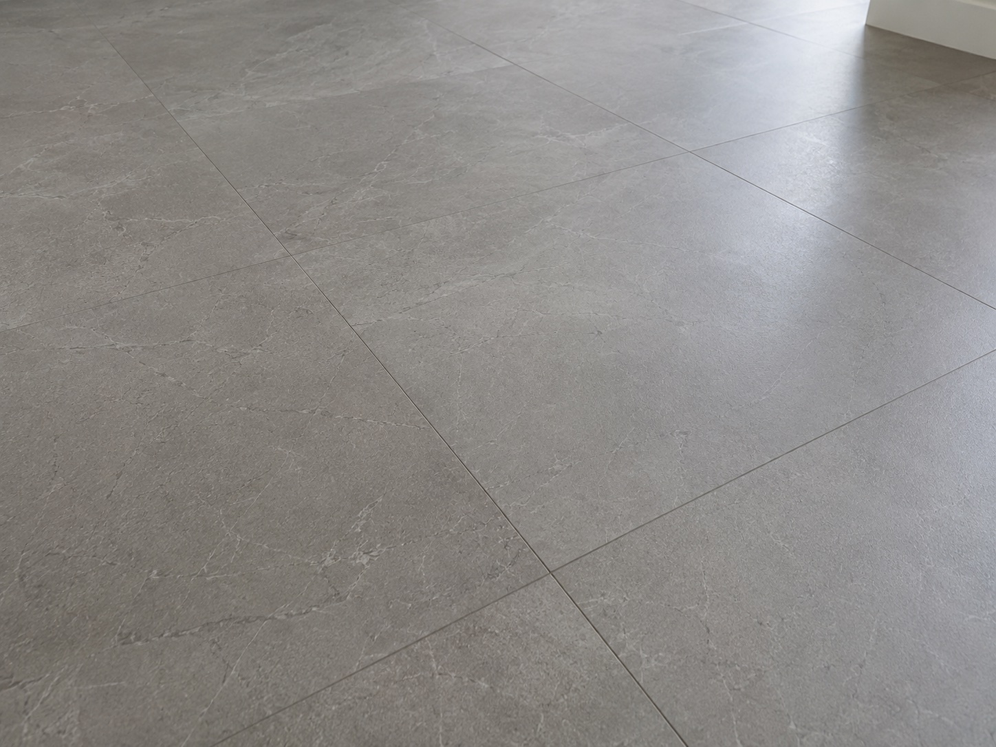 Light grey tile floor after grout line and handover detail cleaning