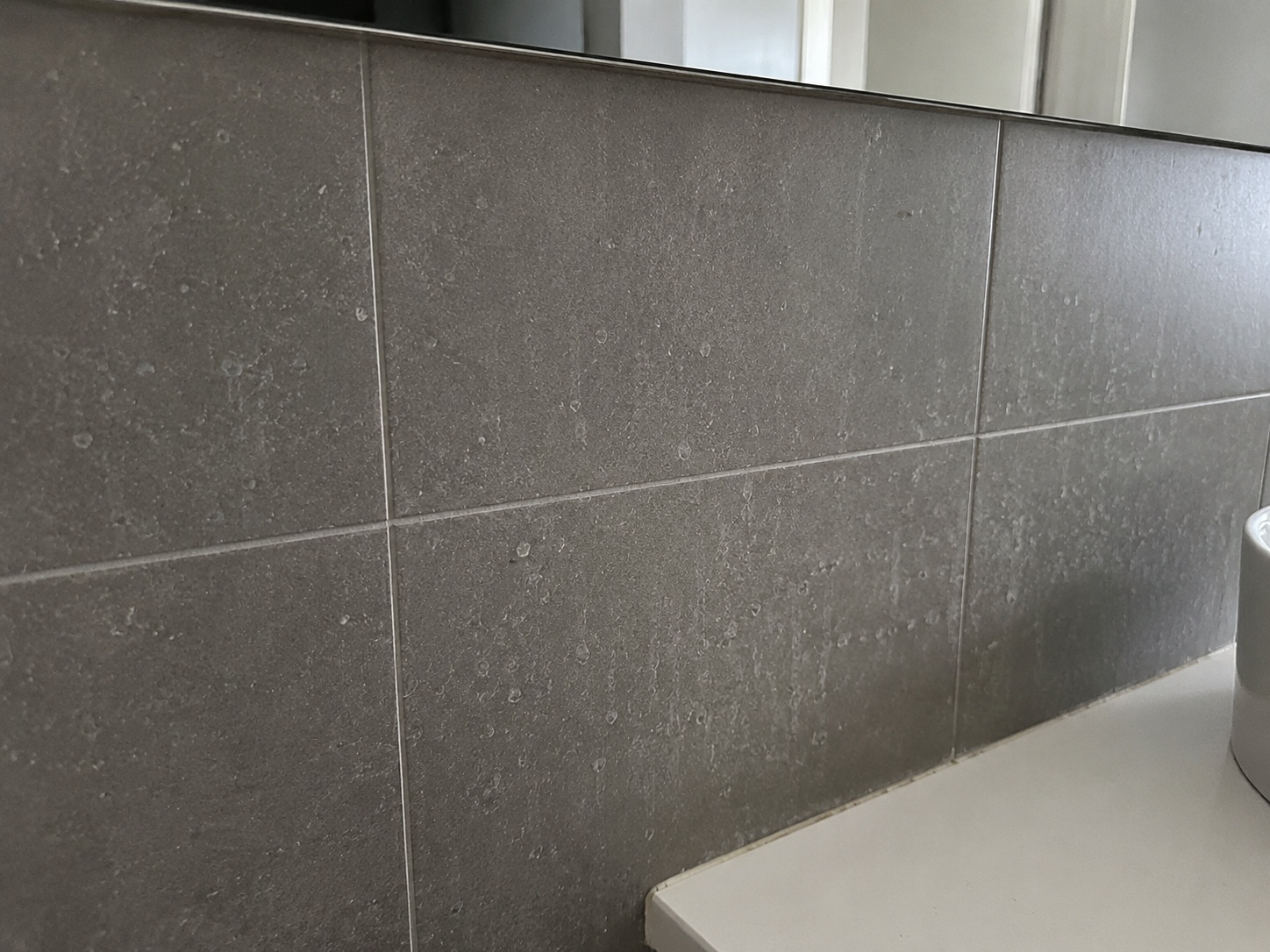 Tiled splashback with residue before handover detailing