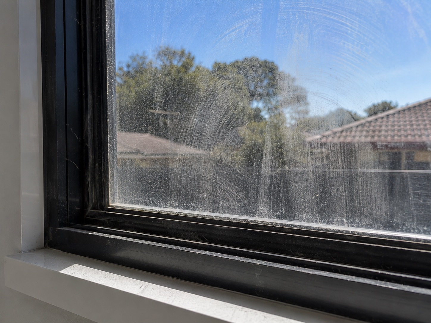 Window glass showing streaks and cleaning residue before the final detail