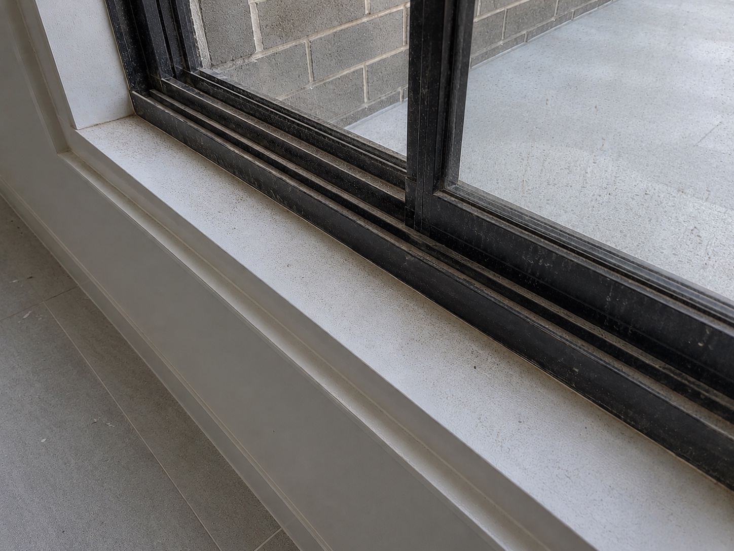 Window track and sill filled with fine construction dust before detailed cleaning